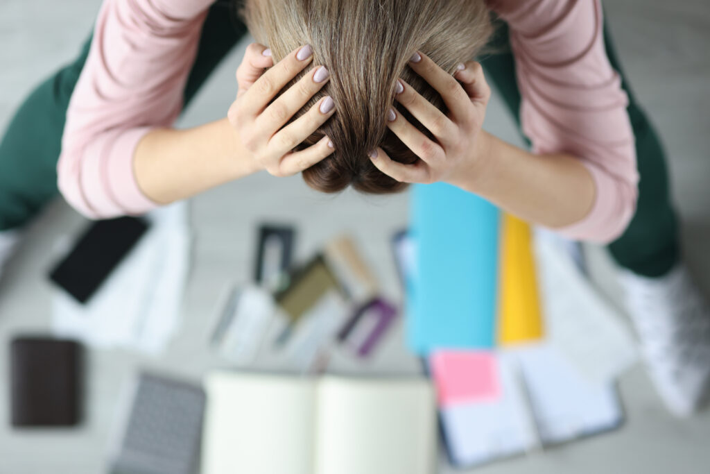 Stressed woman bent over bank cards and checks. Women's spending and family budget concept